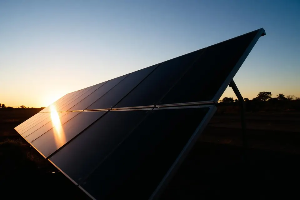 Painéis solares instalados em pequena propriedade rural ao entardecer